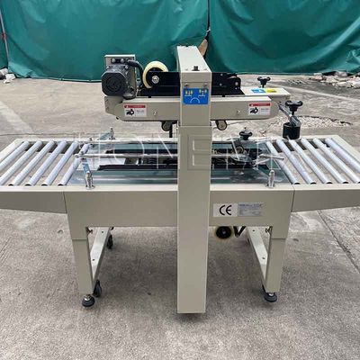 220V / 50HZ स्वचालित पैकिंग मशीन 12 मिमी कार्टन बॉक्स सीलर चिपकने वाला टेपिंग
